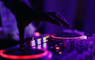 Plan a party on a budget with Carte Blanche Parties. Hand over dj decks with purple lighting in background