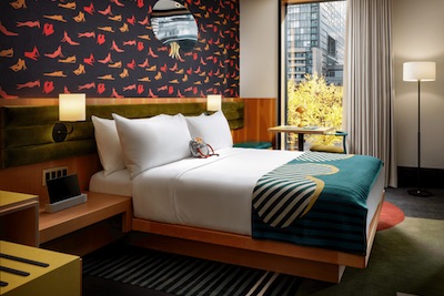 Inside drake hotel bedroom with colourful wallpaper and bright accessories