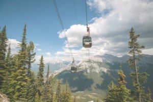 Gondola overlooking pine trees and mountains