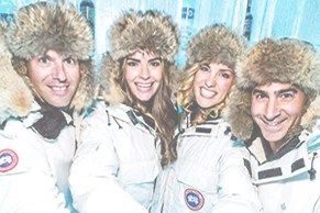 People in ice bar wearing snow jackets