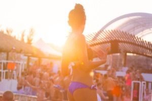 Woman in bikini with background of people at beach club party