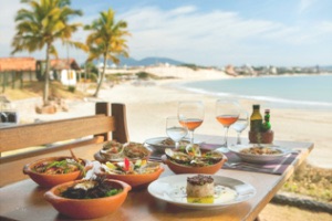 Table at restaurant with plates and cocktails set up overlooking beach