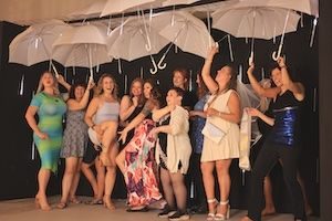 Girls posing for picture with white umbrellas in museum