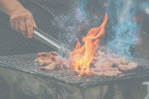 Meat sizzling on barbeque with flames
