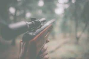 Close up shot of rifle being pointed in forest