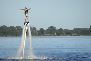 Man soaring out of water on jetpack