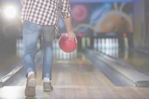 Man about to release bowling ball down lane
