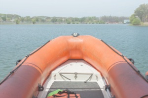 View inside orange inflatable raft looking down blue river