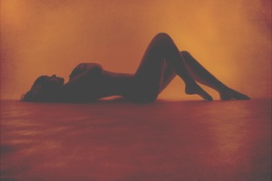 Girl laying down posing sexy in red light