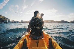 Girl in orange kayak paddling into soft waves