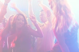 Friends throwing hands in air in nightclub