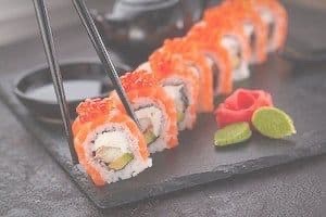 Close up of sushi rolls & chopsticks on plate