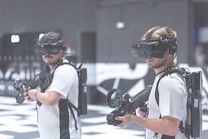 Two boys with VR goggles holding VR guns