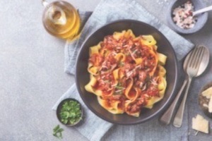 Italian pasta dish with herbs on side