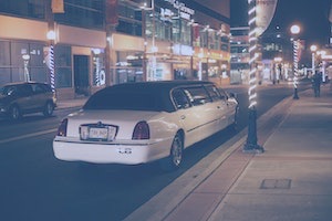 White limousine parked on street in evening