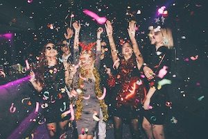 Girls laughing and dancing with confetti spraying in front