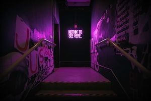 Dark staircase with neon lights lit in background